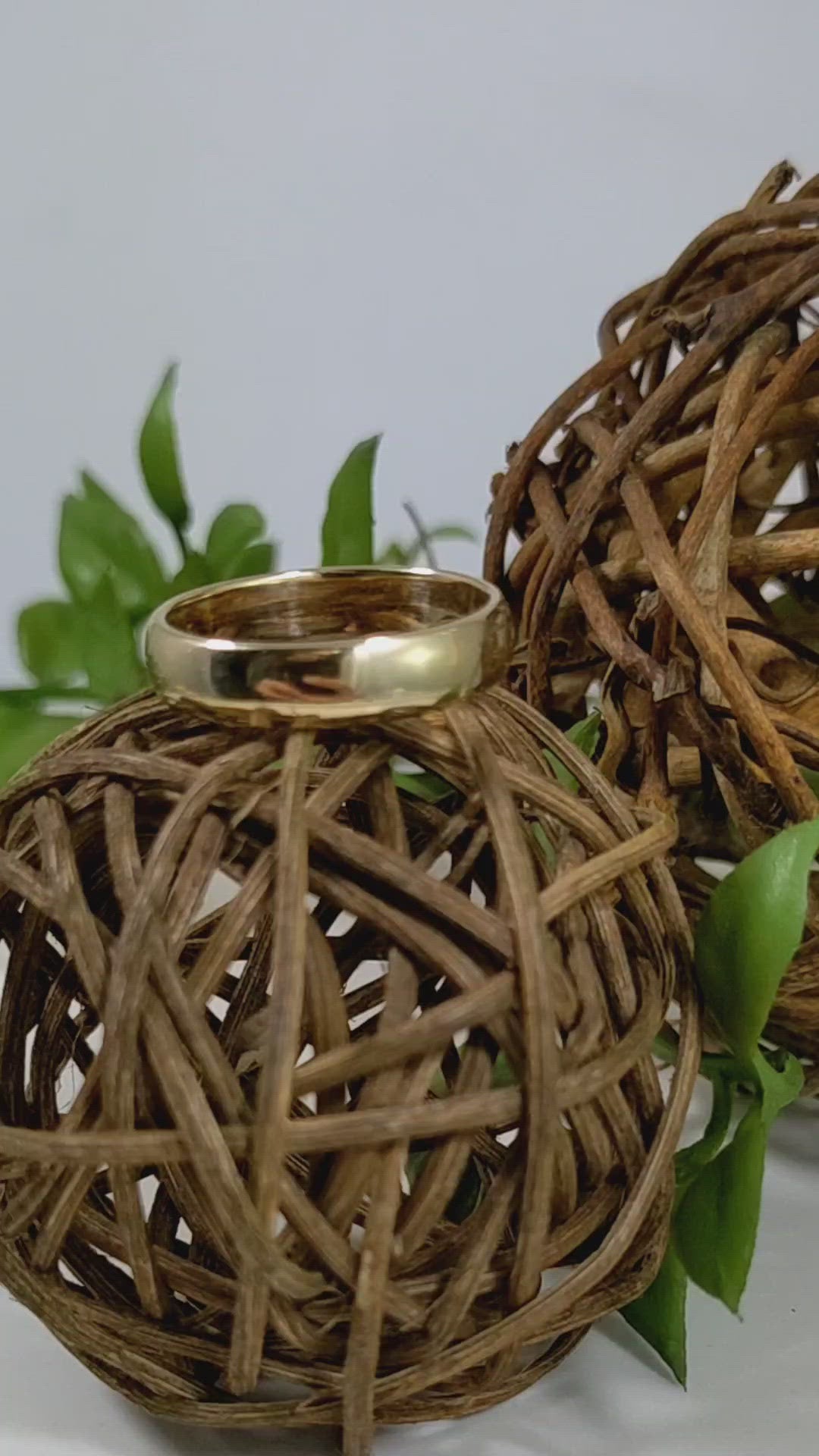 A video of a slightly domed, polished, solid 14k yellow gold ring band, 5mm thick.
