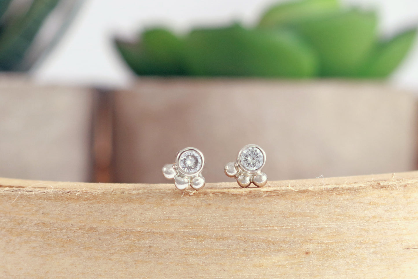Studs with 3mm white diamonds set in 14k white gold with 3 bubbles in a group at the bottom.