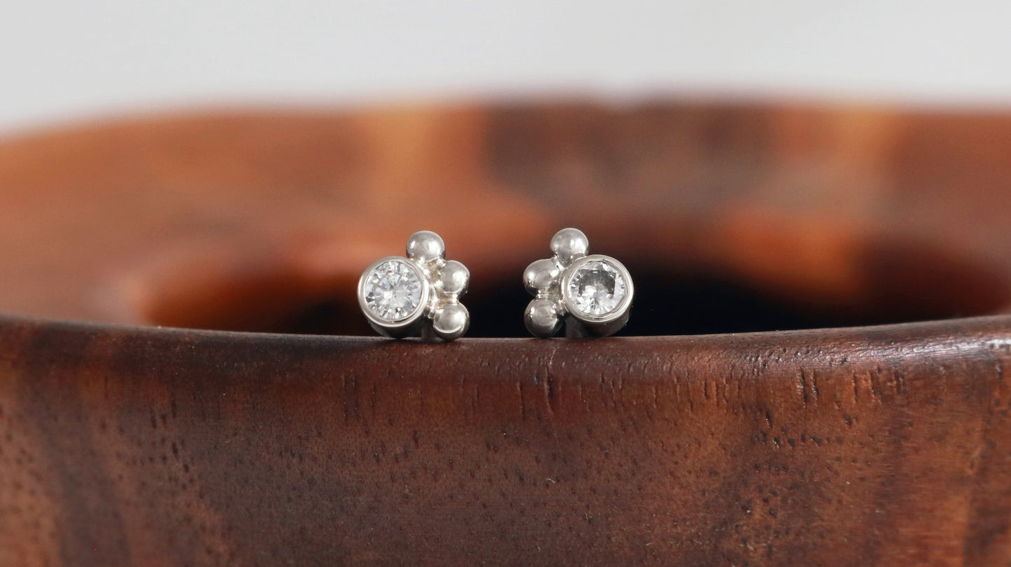 Studs with 3mm white diamonds set in 14k white gold with 3 bubbles in a group at the bottom.