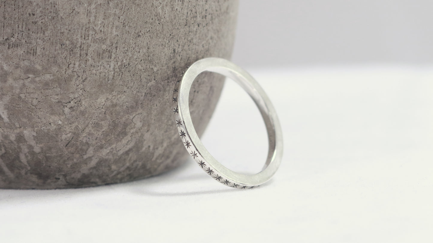 2mm squared ring band with black hand carved stars around the entire band.