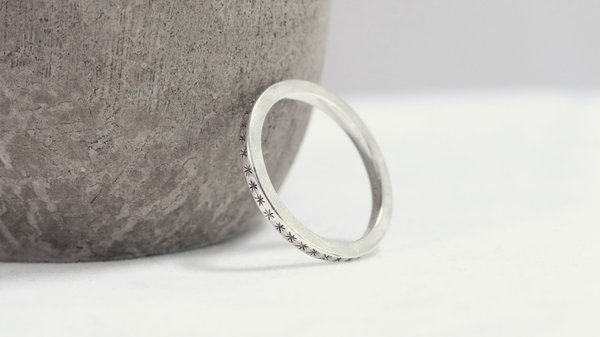 2mm squared ring band with black hand carved stars around the entire band.