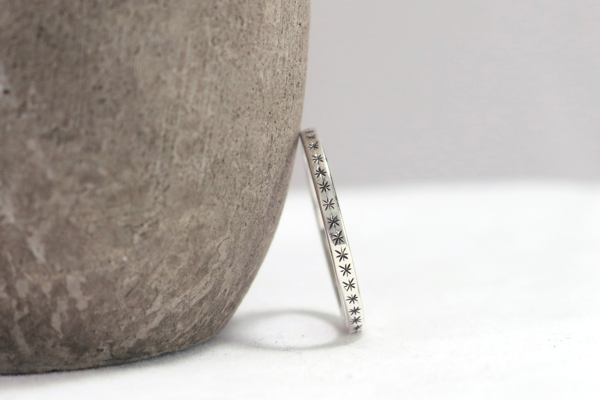 2mm squared ring band with black hand carved stars around the entire band.