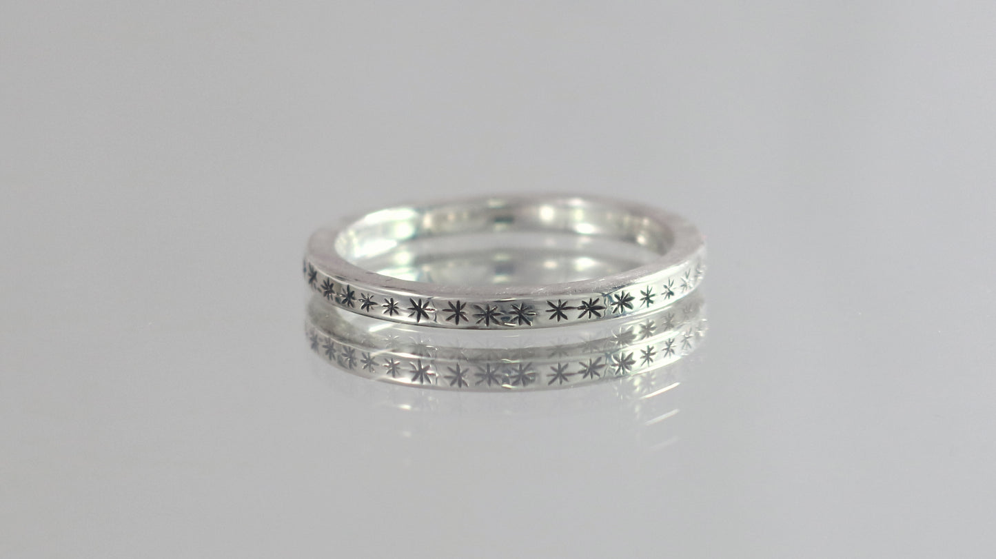 2mm squared ring band with black hand carved stars around the entire band.
