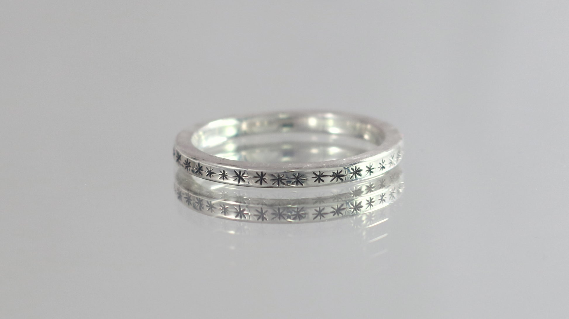 2mm squared ring band with black hand carved stars around the entire band.