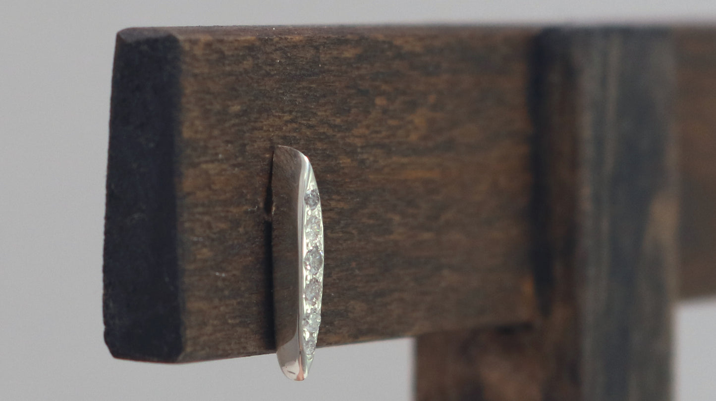 Studs made from solid sterling silver, shaped like a pointed ellipse, bead set with 6 diamonds descending in size.
