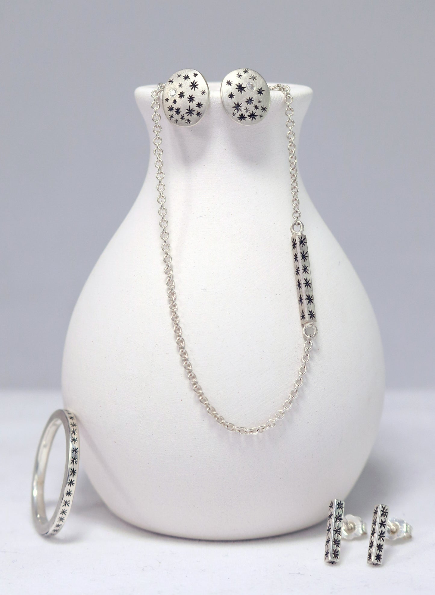 Sterling silver bar necklace with hand cut black stars on every side on a sterling silver chain.