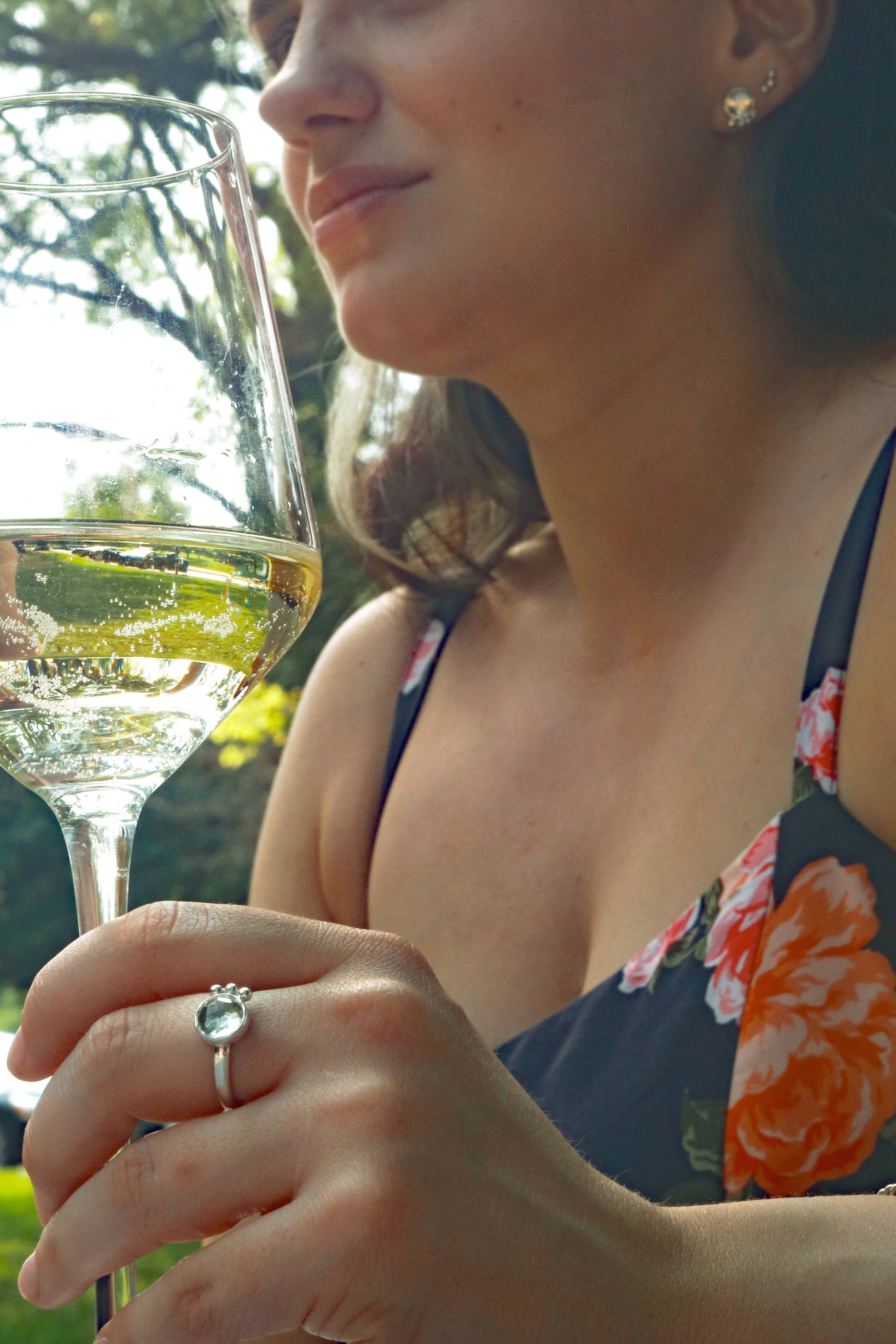 A model wearing a silver ring with an 8mm round rose cut green amethyst gemstone set in sterling silver. 3 Silver bubble accents aligned along the side.