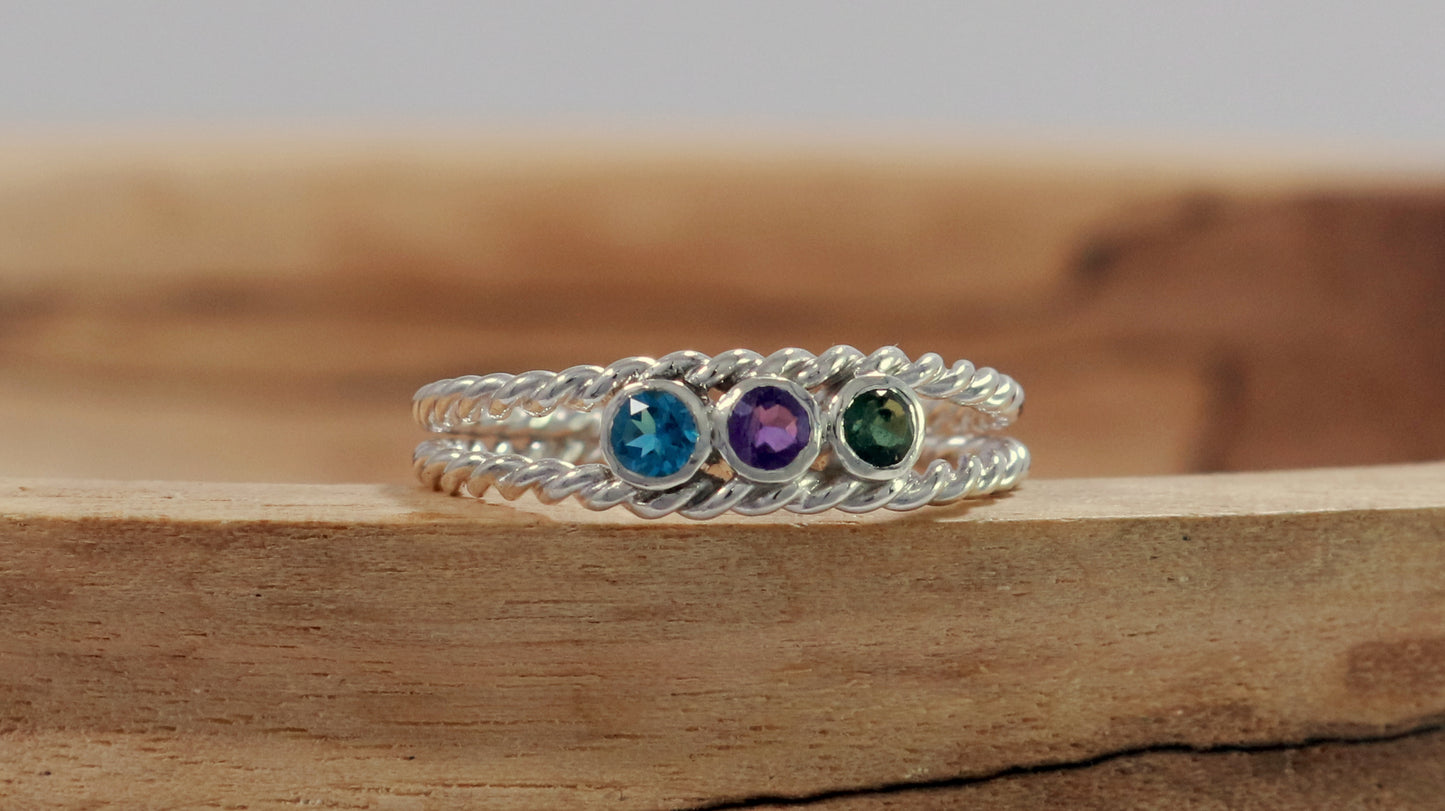 3 round natural gemstones bezel set in sterling silver between two twisted silver ring bands.