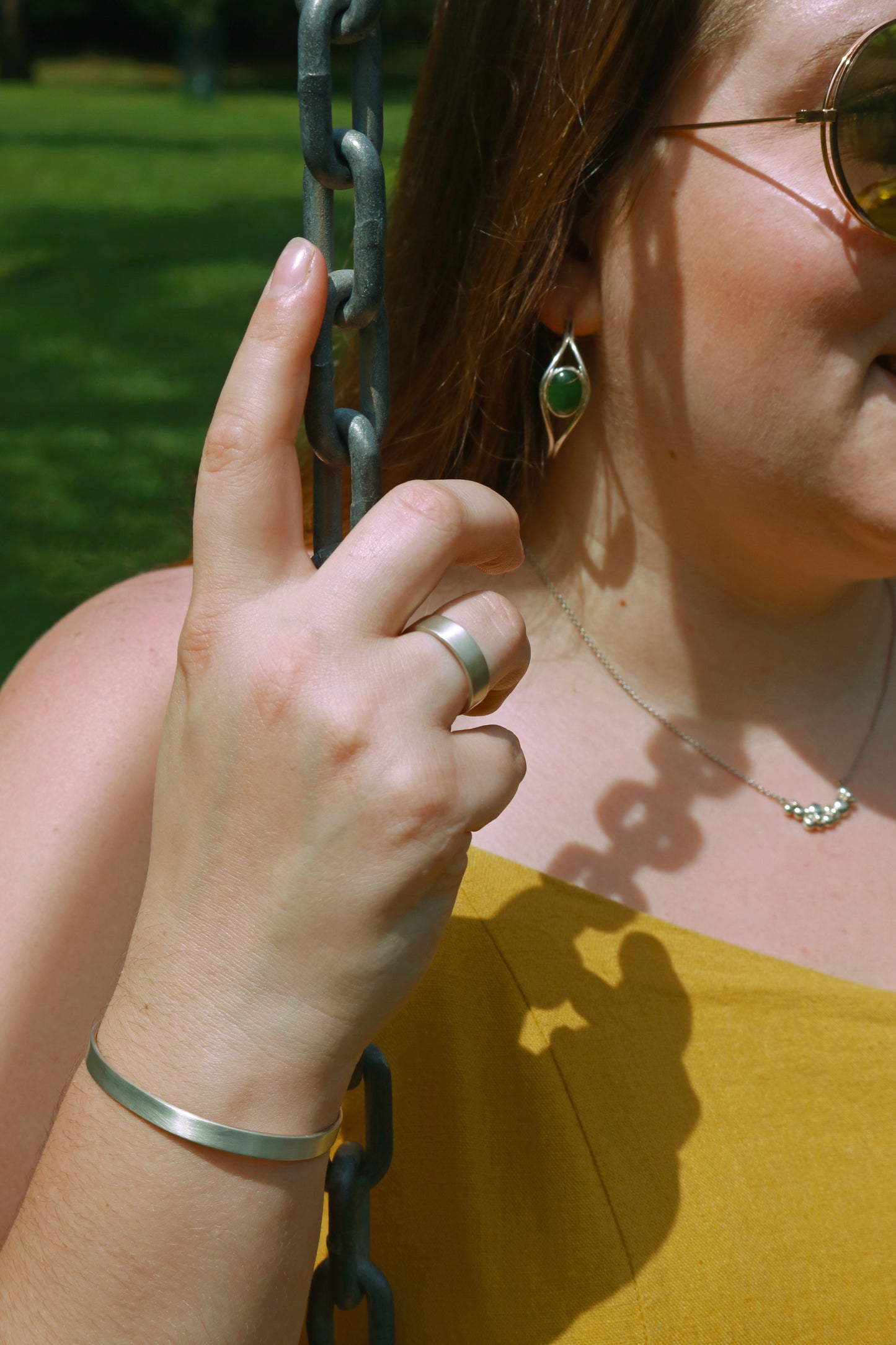 A model wearing a sterling silver ring band with a matte finish outside & polished finish inside, 6mm wide, 1.7mm thick.