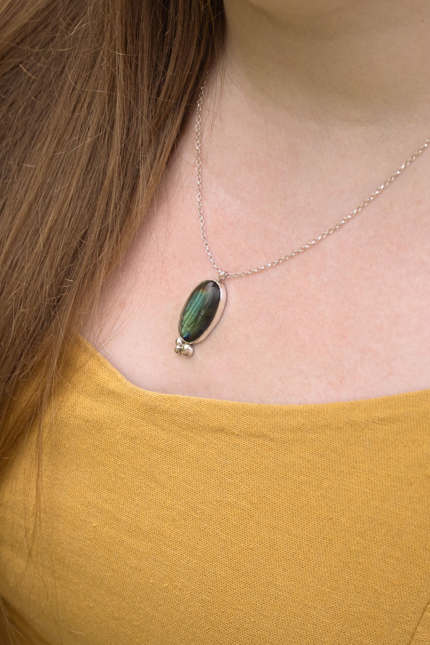 Oval natural Labradorite gemstone set in sterling silver bezel with 4 bubble cluster accent on a sterling silver chain.