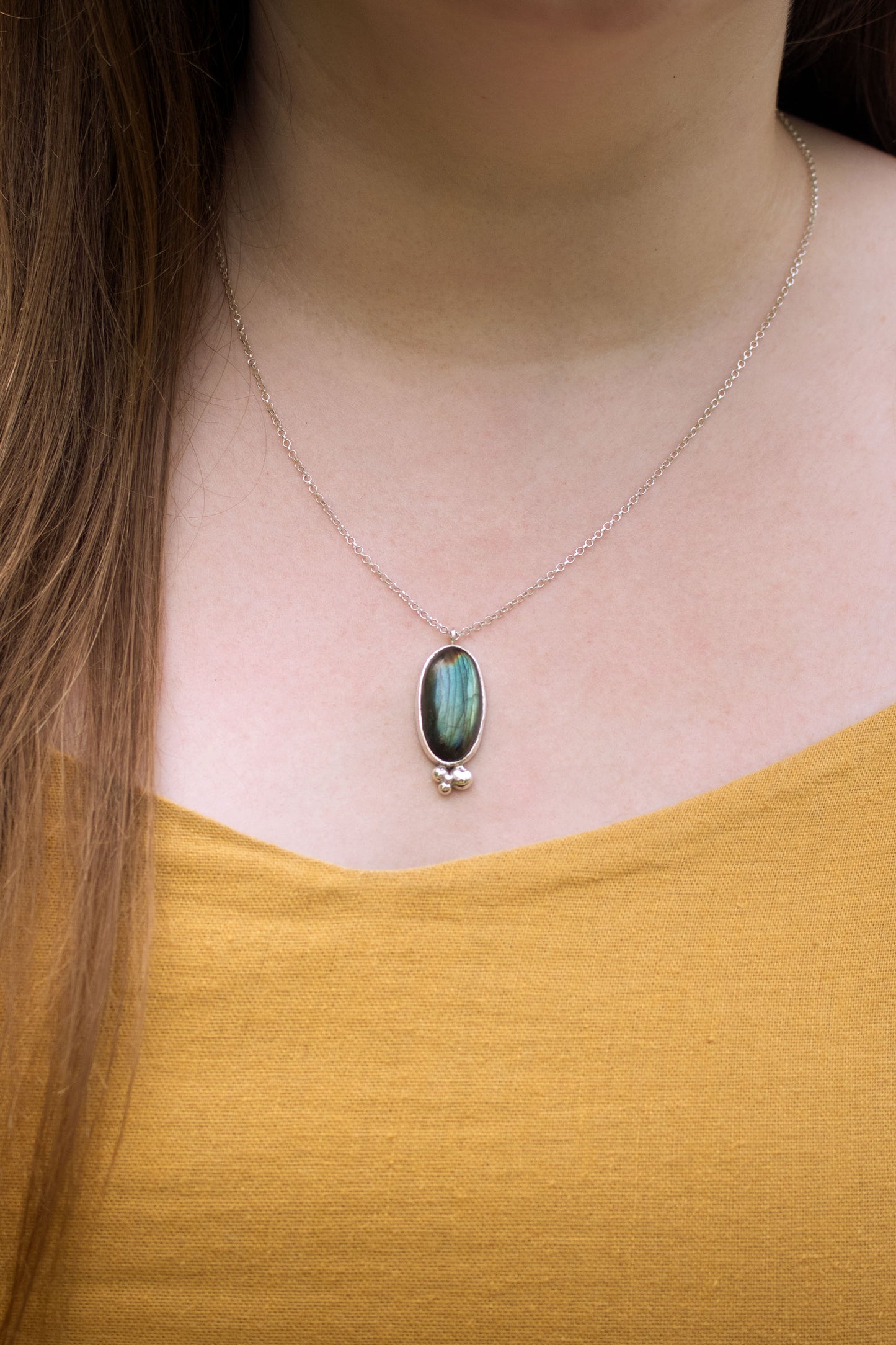 Oval natural Labradorite gemstone set in sterling silver bezel with 4 bubble cluster accent on a sterling silver chain.