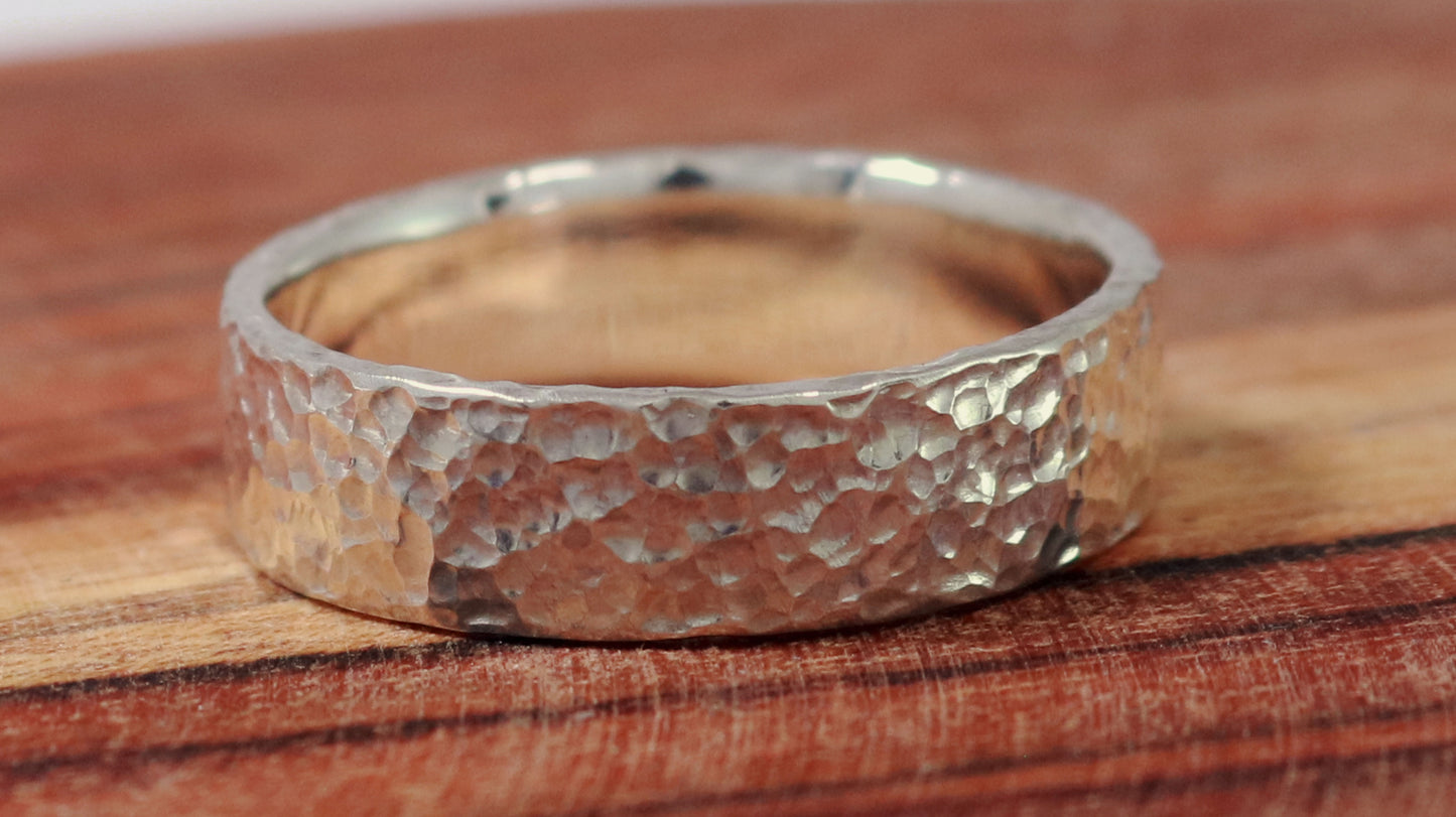 A polished solid sterling silver ring band, 6mm wide, with small dimpled hammer texture.