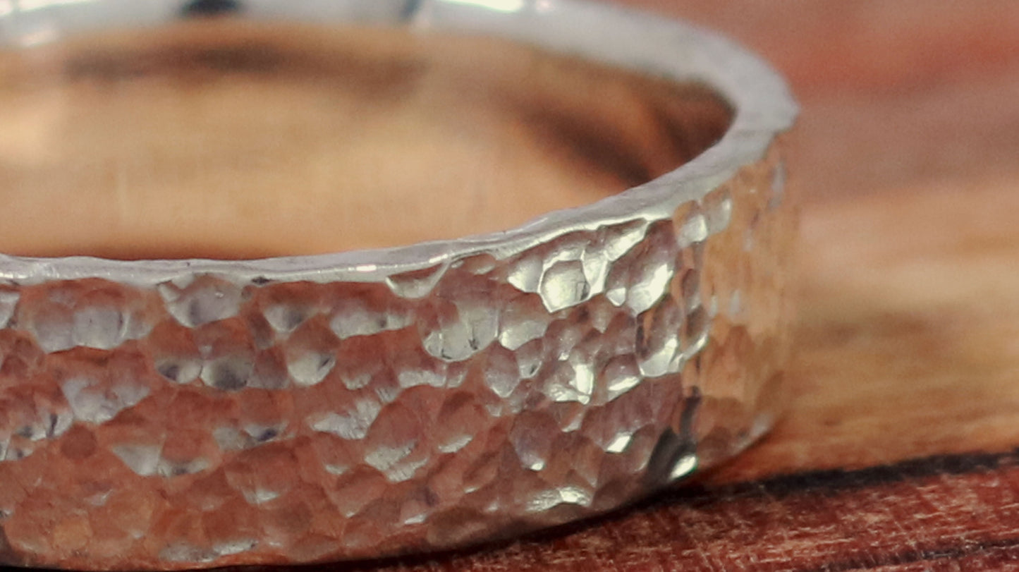 A polished solid sterling silver ring band, 6mm wide, with small dimpled hammer texture.