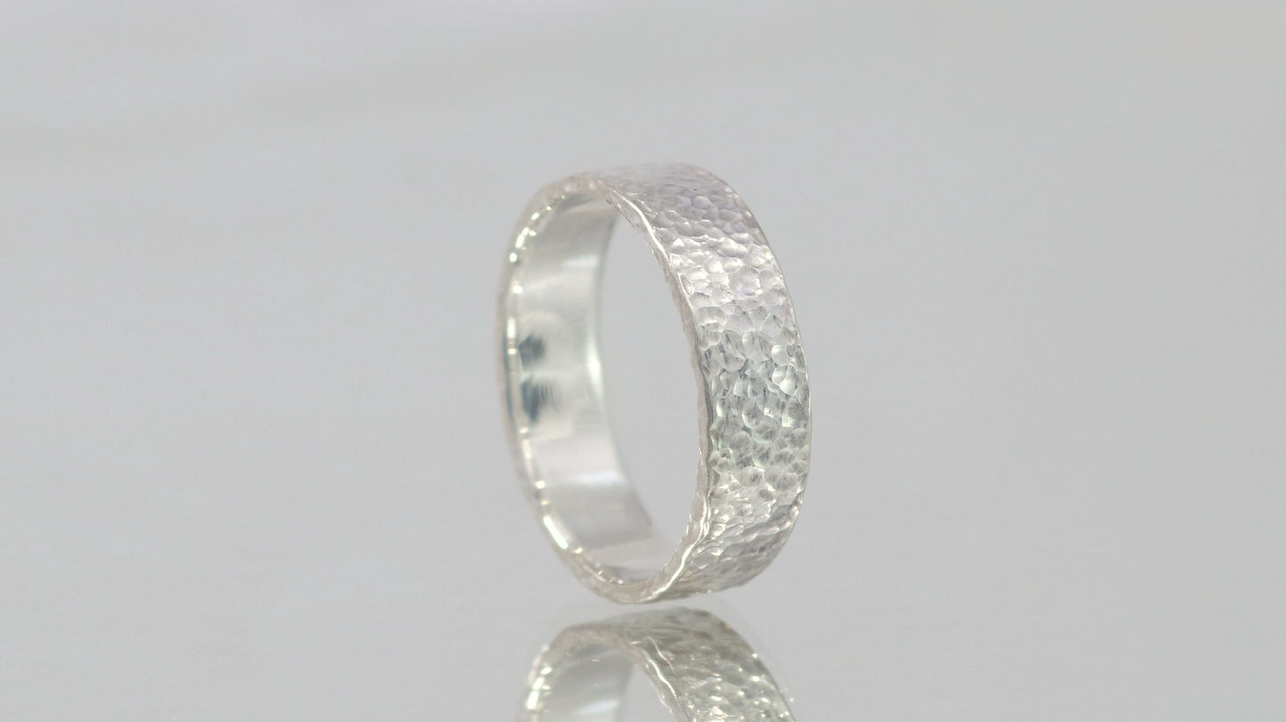 A polished solid sterling silver ring band, 6mm wide, with small dimpled hammer texture.