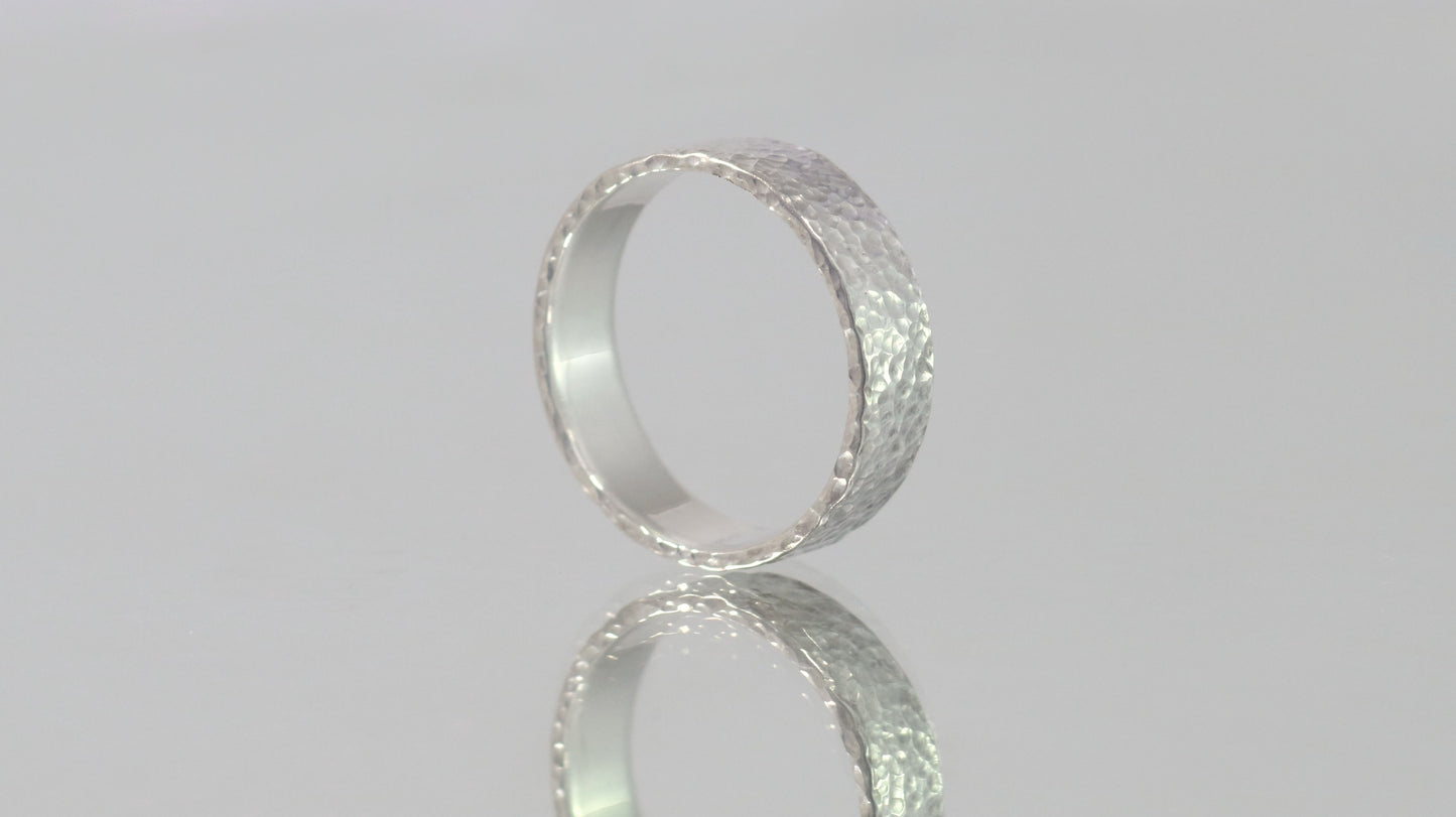 A polished solid sterling silver ring band, 6mm wide, with small dimpled hammer texture.