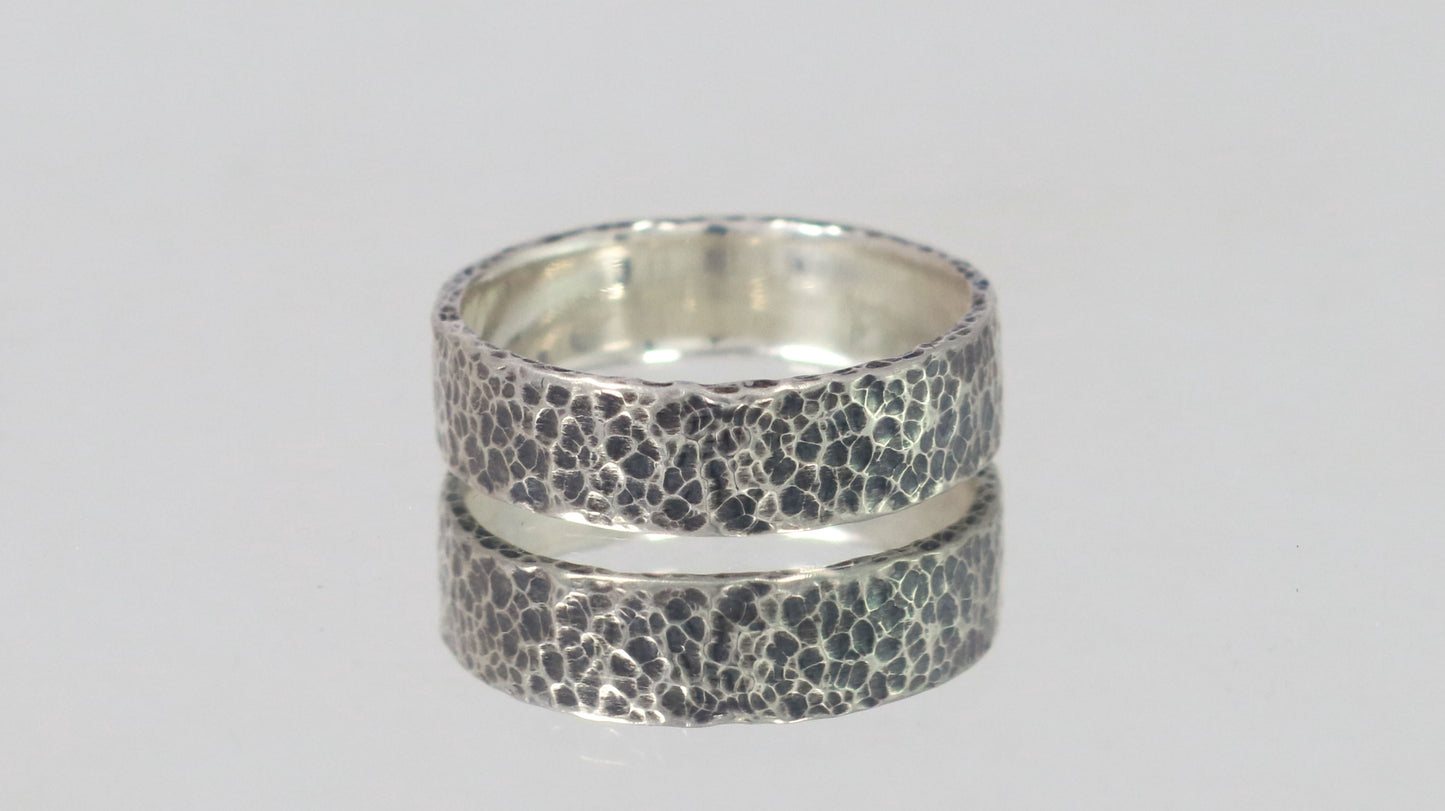 A darkened solid sterling silver ring band, 6mm wide, with small dimpled hammer texture.