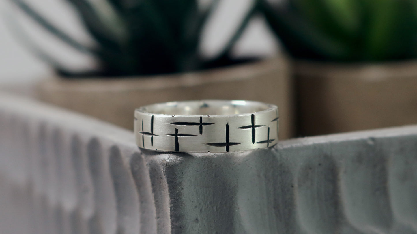 Black cross hatch marks all around this 6mm sterling silver ring band.