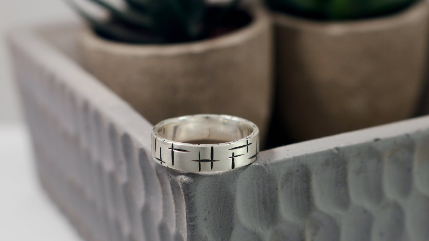 Black cross hatch marks all around this 6mm sterling silver ring band.