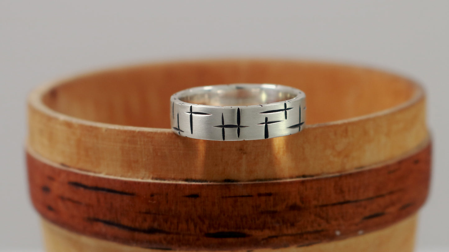 Black cross hatch marks all around this 6mm sterling silver ring band.
