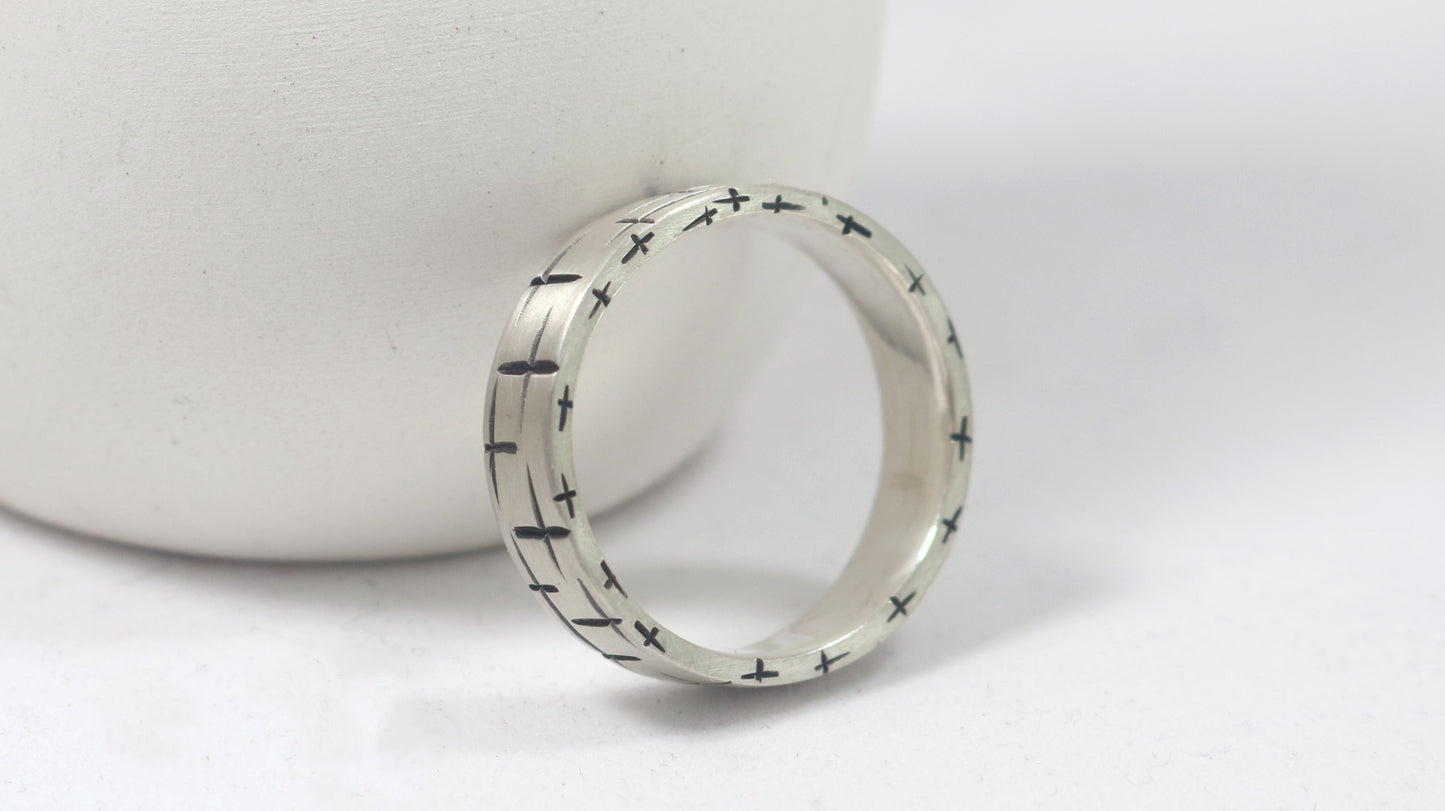 Black cross hatch marks all around this 6mm sterling silver ring band.