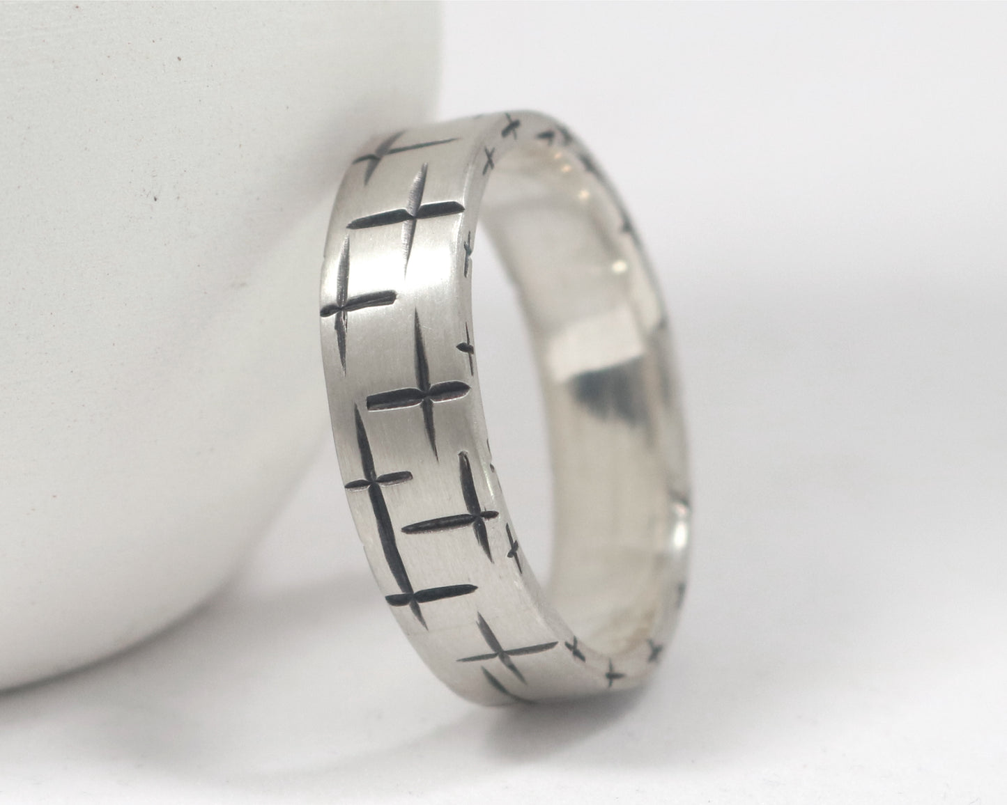 Black cross hatch marks all around this 6mm sterling silver ring band.