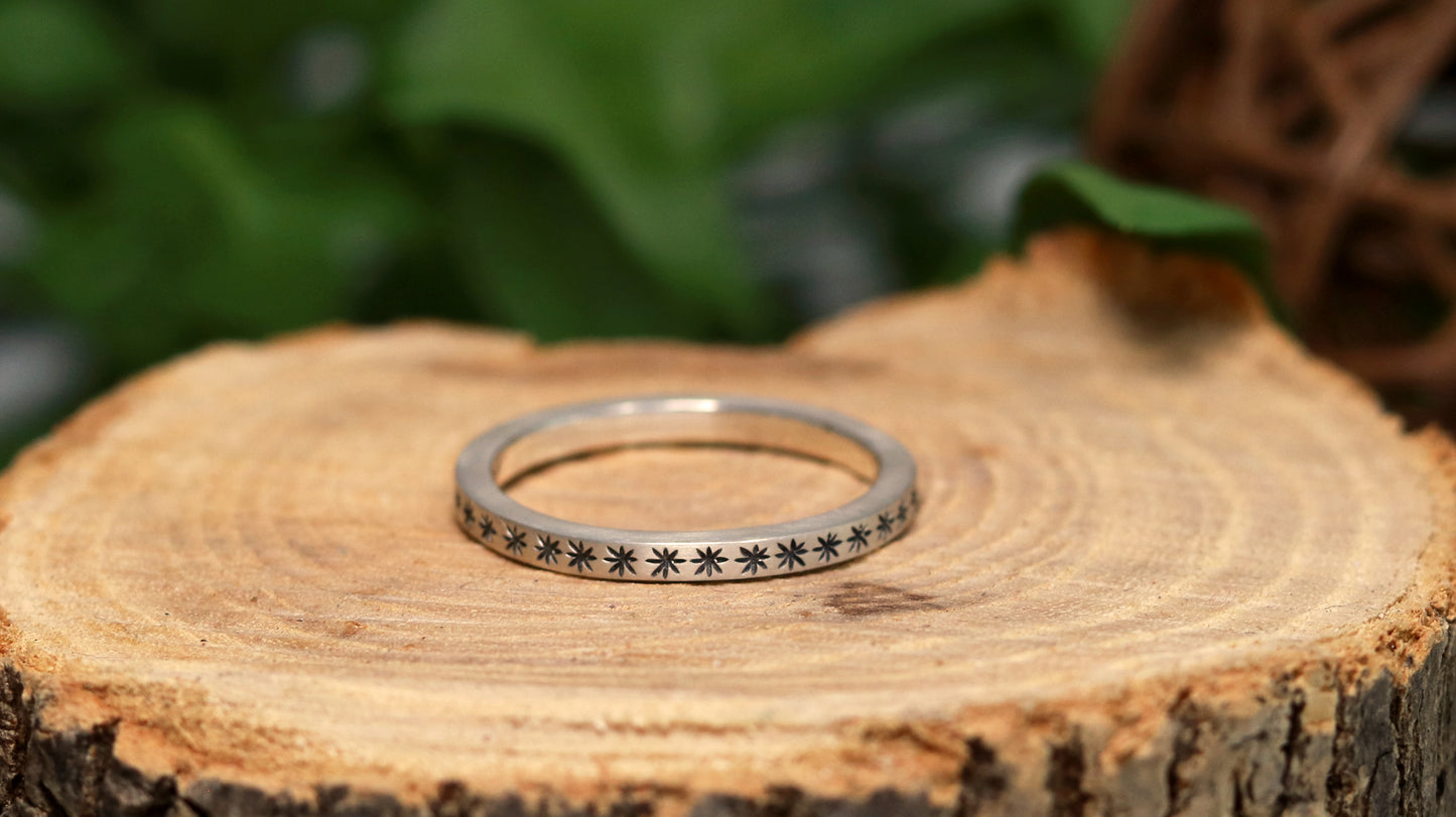 2mm squared ring band with black hand carved stars around the entire band.