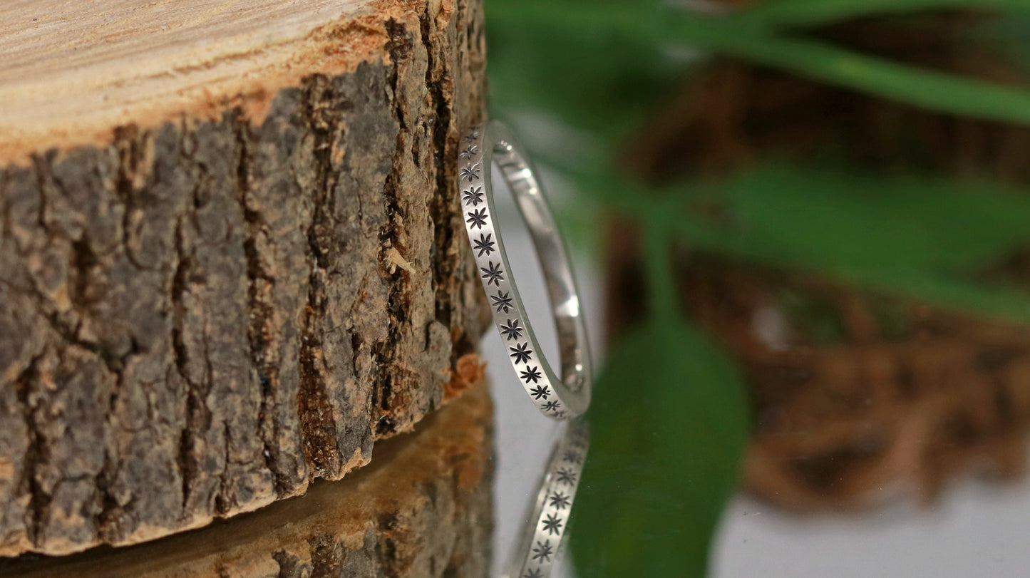 2mm squared ring band with black hand carved stars around the entire band.