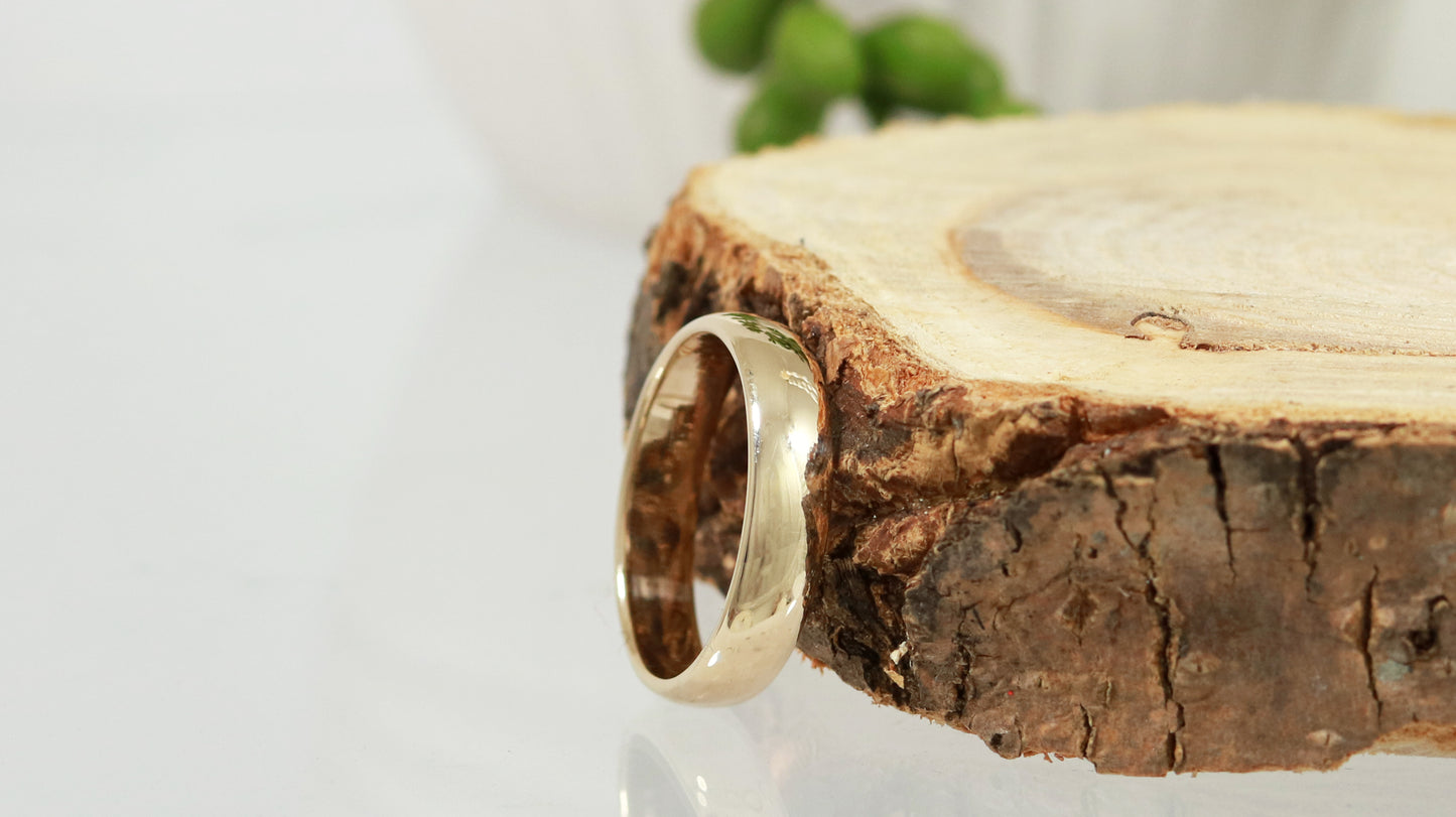 A slightly domed, polished, solid 14k yellow gold ring band, 5mm thick.