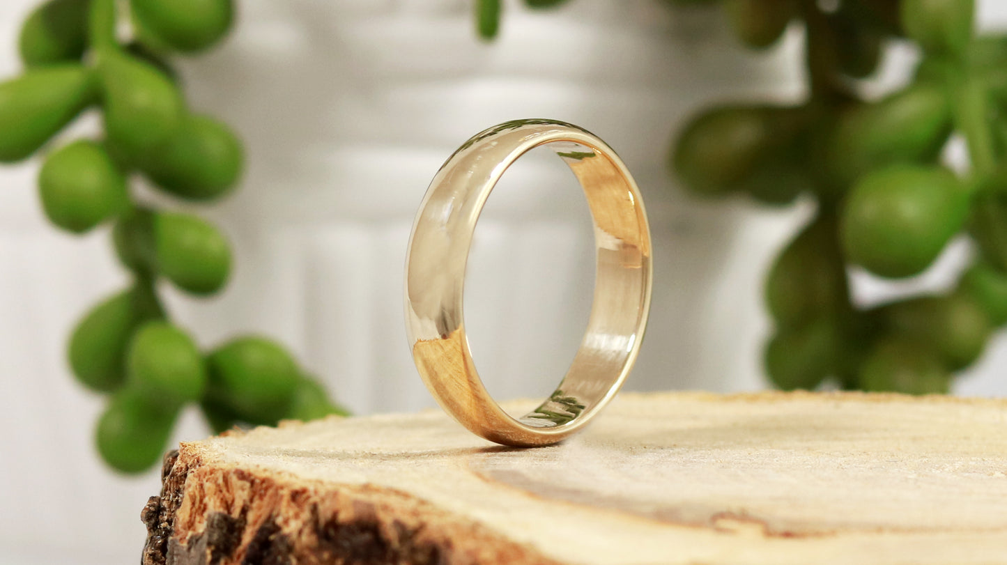 A slightly domed, polished, solid 14k yellow gold ring band, 5mm thick.