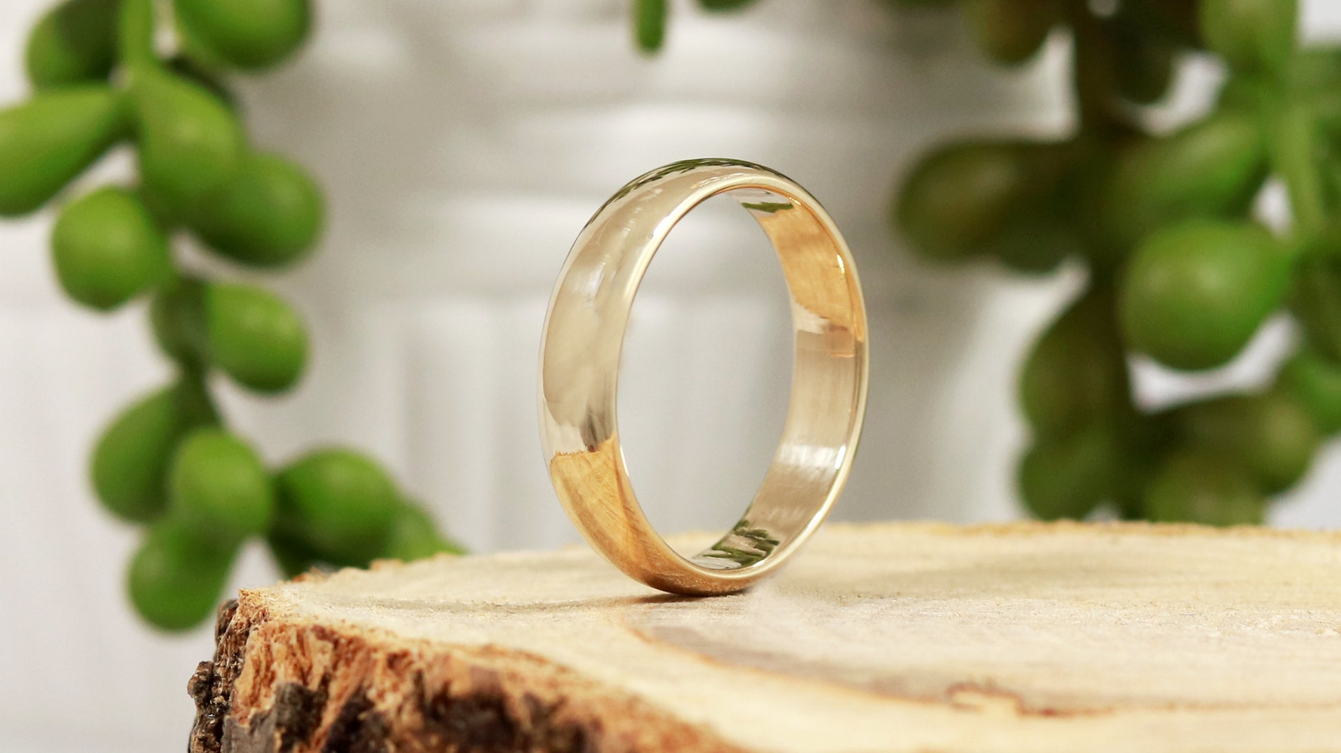 A slightly domed, polished, solid 14k yellow gold ring band, 5mm thick.