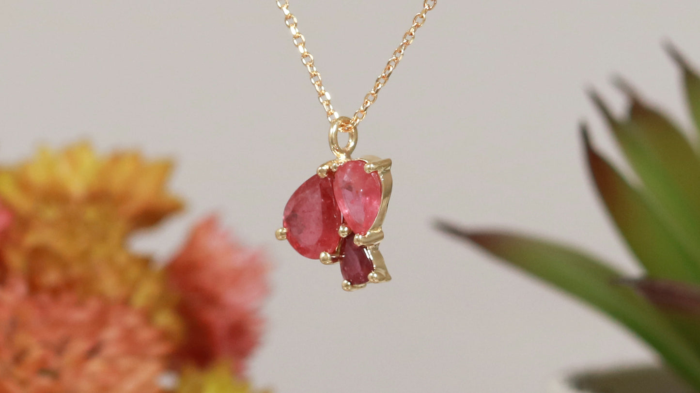3 natural pear rubies in different shades of red set in solid 14k yellow gold on a gold chain.