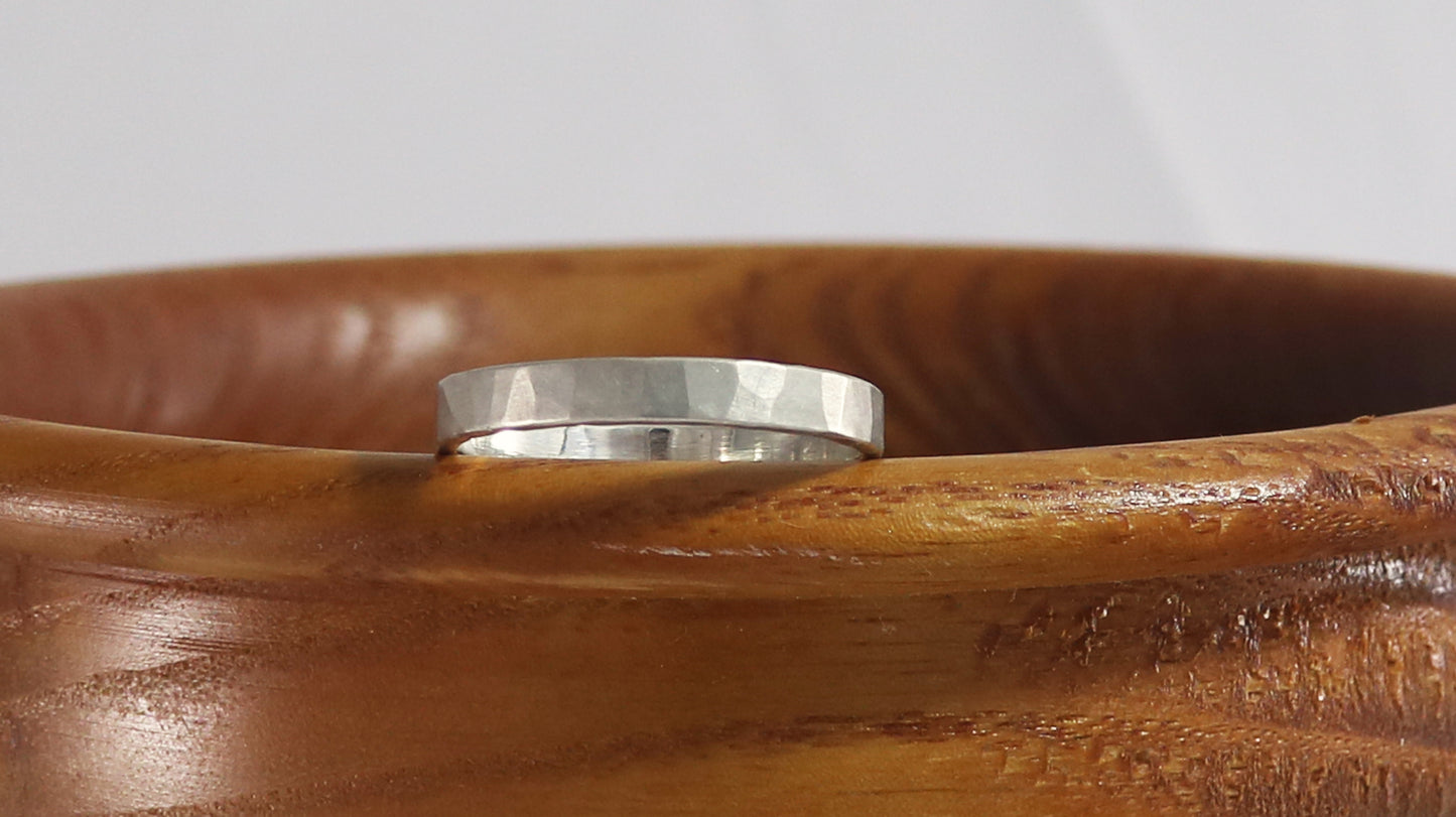 A 4mm silver ring band with a soft hammer texture.
