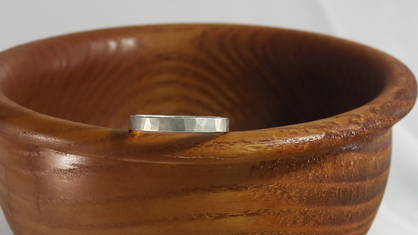 A 4mm silver ring band with a soft hammer texture.