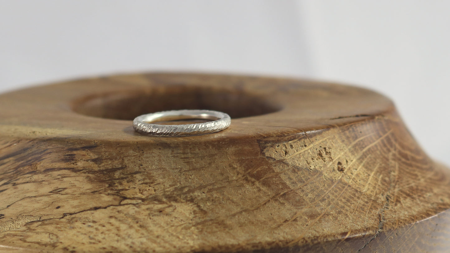 A thick sterling silver ring band with a rough hammer texture.