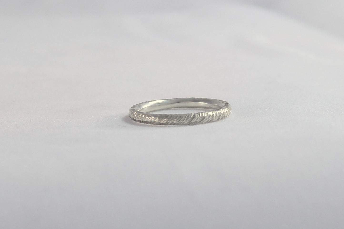 A thick sterling silver ring band with a rough hammer texture.