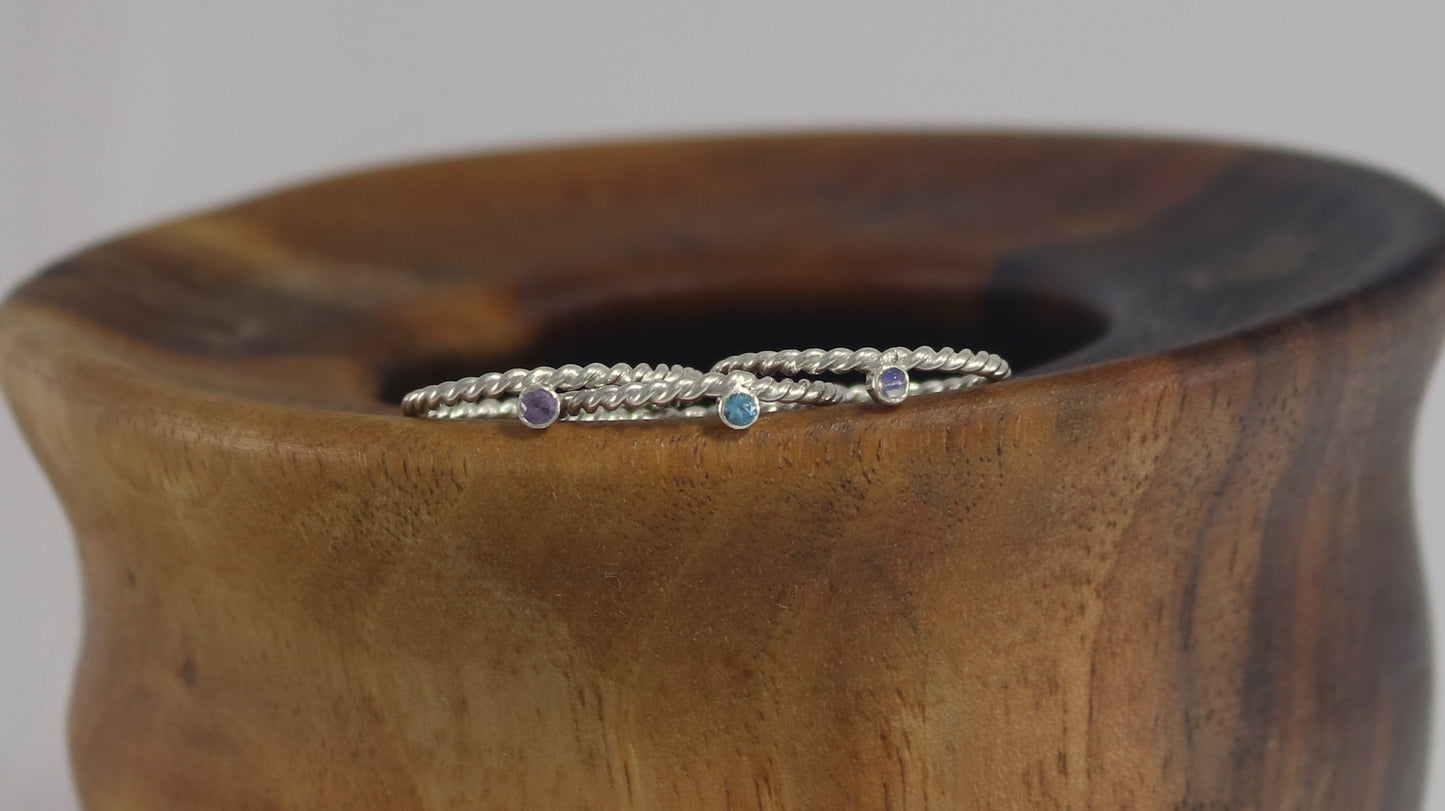 Round natural gemstone set in a sterling silver bezel on a twisted sterling silver ring band.