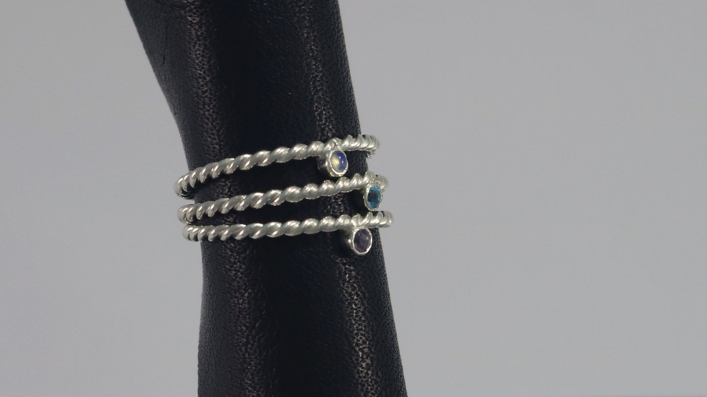 Round natural gemstone set in a sterling silver bezel on a twisted sterling silver ring band.