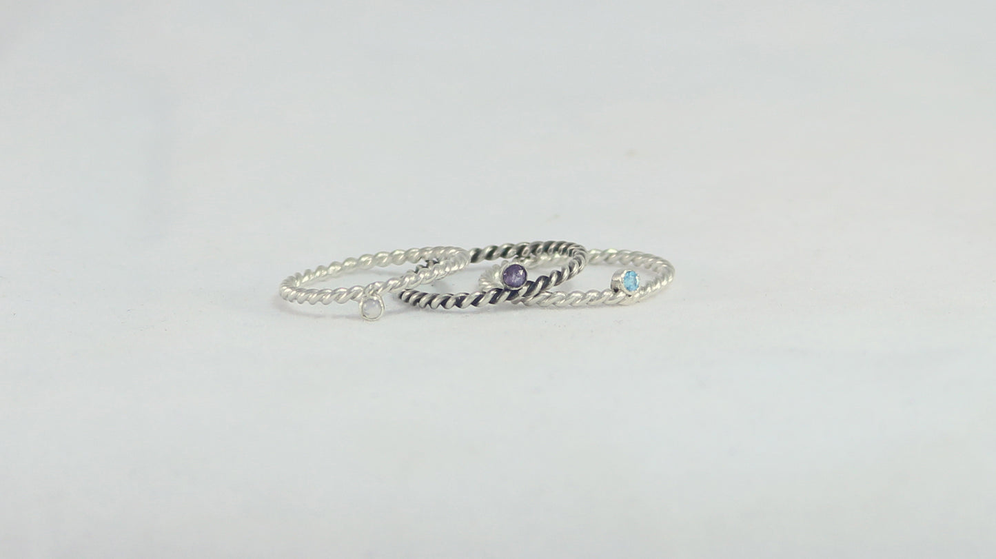 Round natural gemstone set in a sterling silver bezel on a twisted sterling silver ring band.