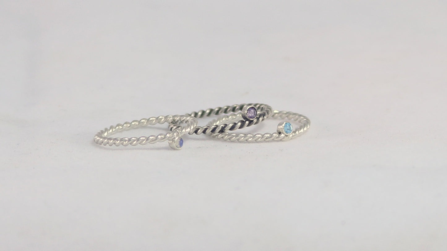 Round natural gemstone set in a sterling silver bezel on a twisted sterling silver ring band.