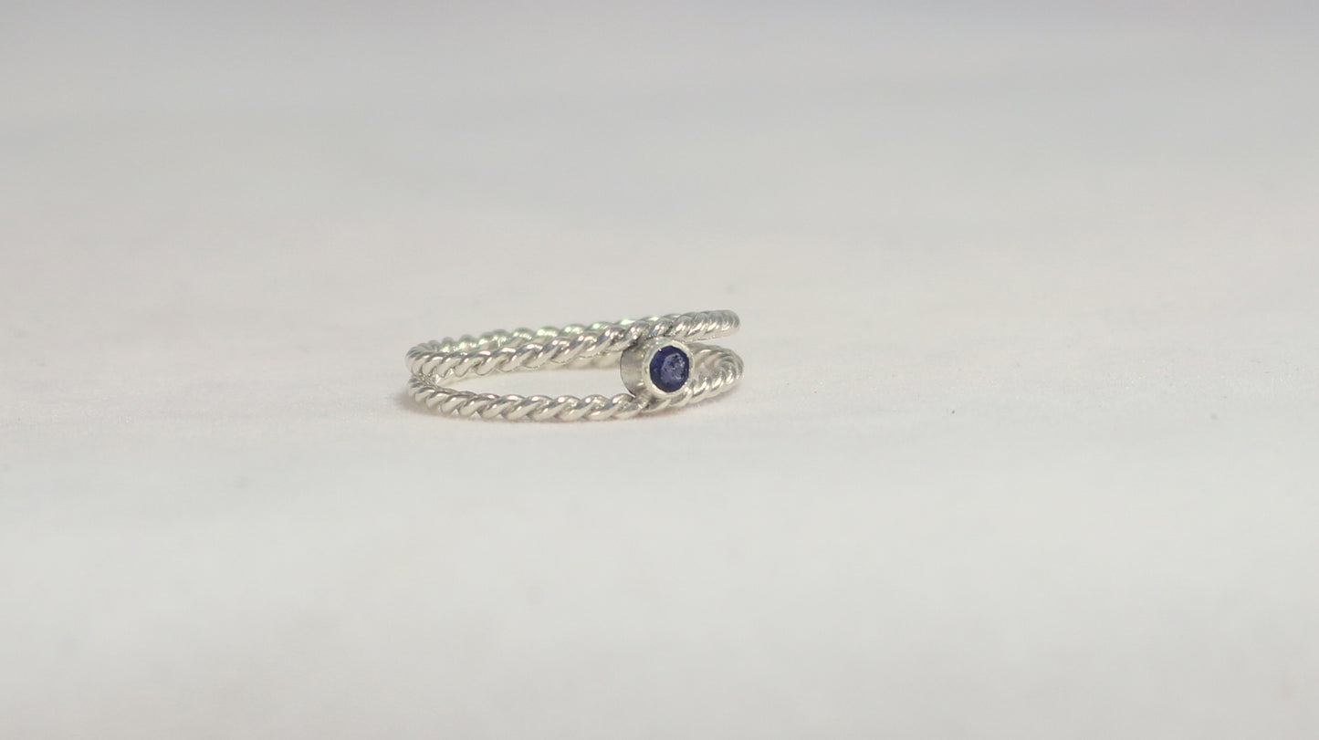 Round natural gemstone set in a sterling silver bezel between two twisted silver ring bands.