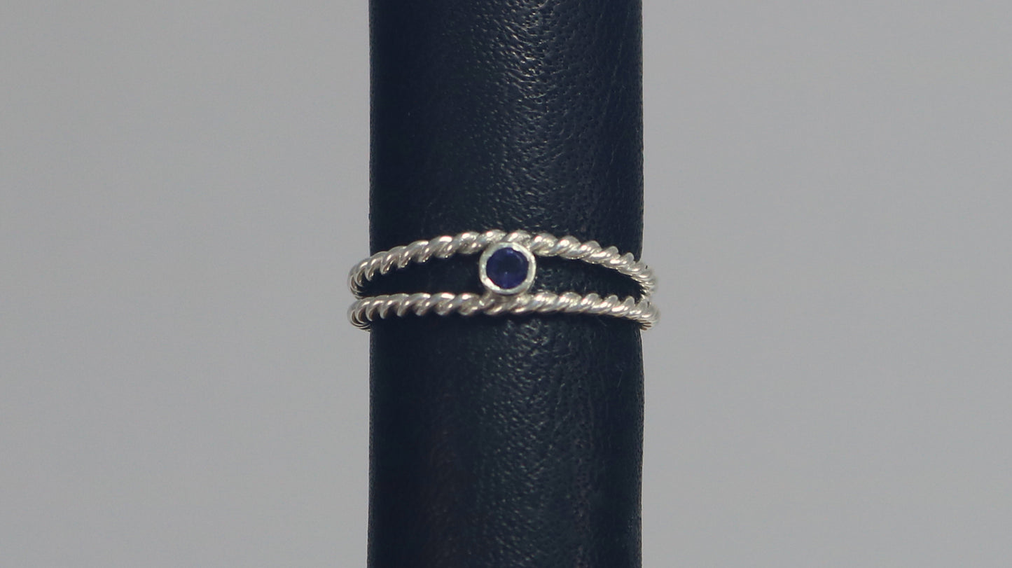 Round natural gemstone set in a sterling silver bezel between two twisted silver ring bands.