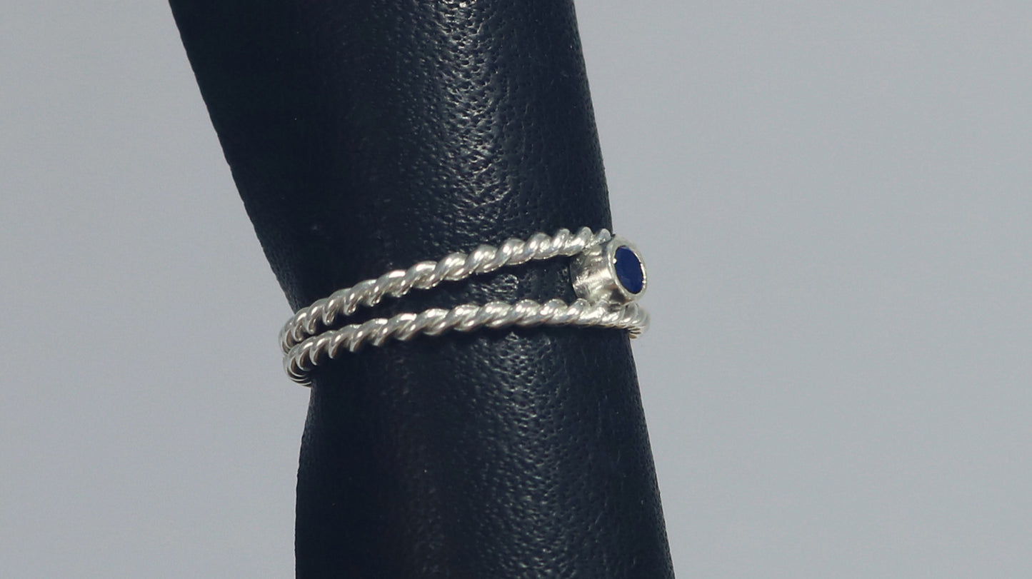 Round natural gemstone set in a sterling silver bezel between two twisted silver ring bands.