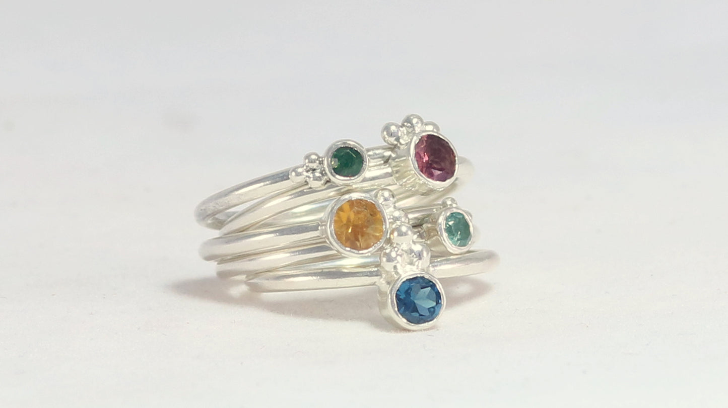 Natural gemstone set in sterling silver bezel on a sterling silver ring band with 3 silver bubbles in a pyramid.