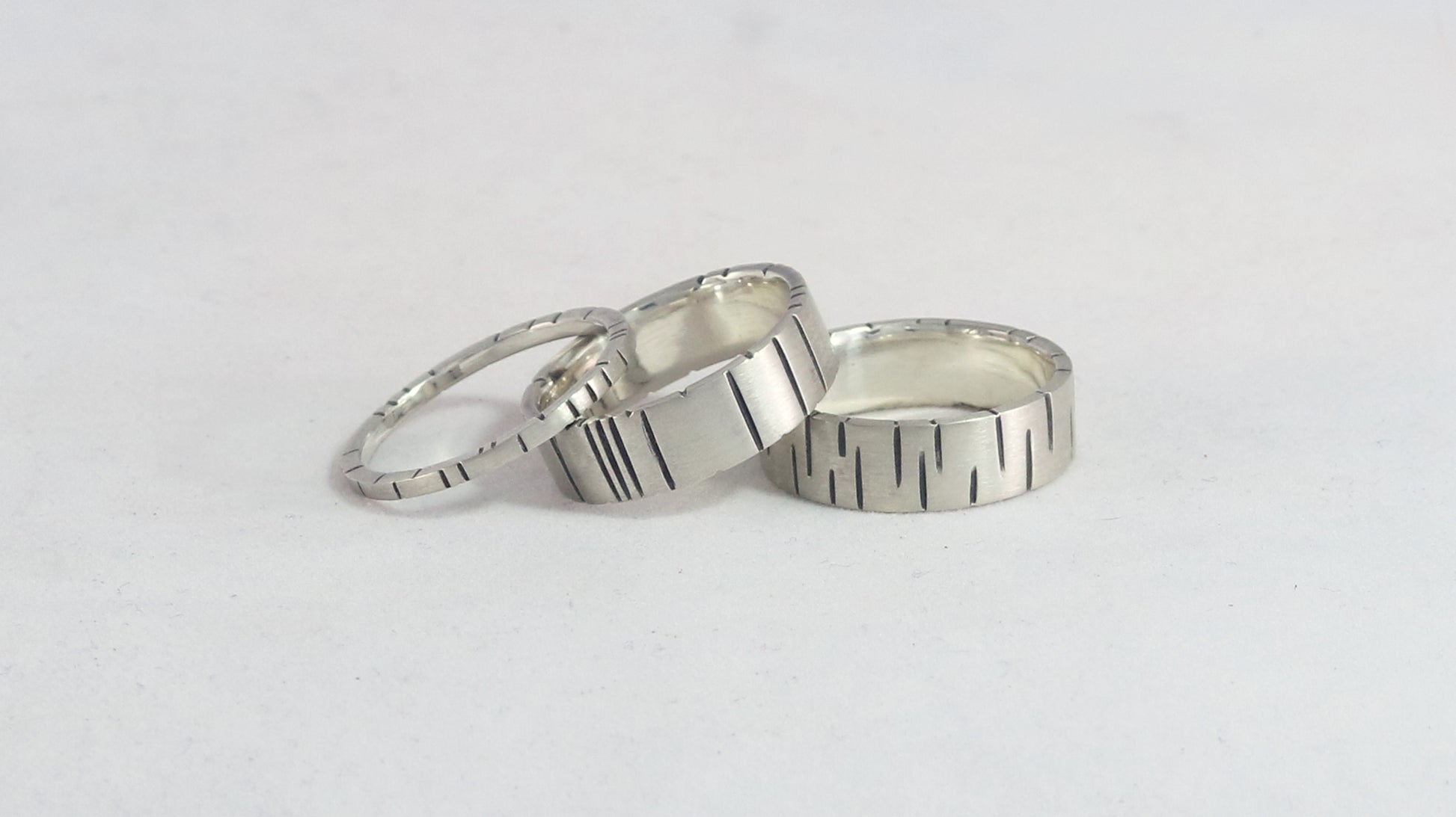 6mm sterling silver ring band with offset, randomly spaced, black lines.