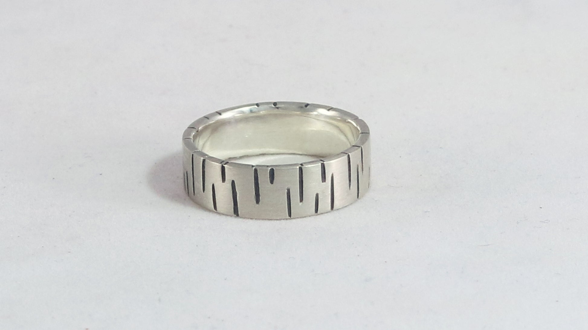 6mm sterling silver ring band with offset, randomly spaced, black lines.