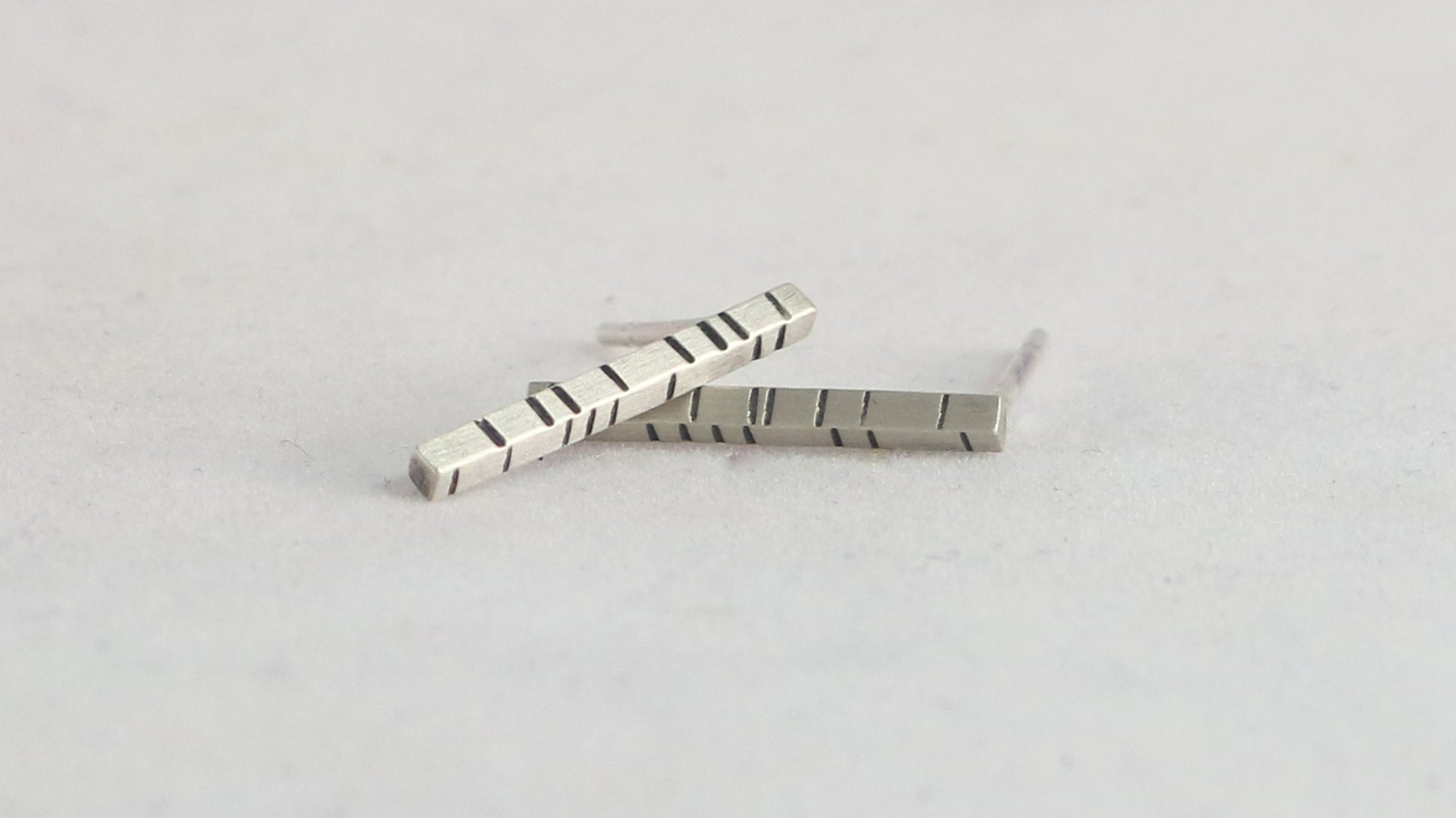 1.5mm thick solid sterling silver, rectangle bar studs with randomly spaced black lines.
