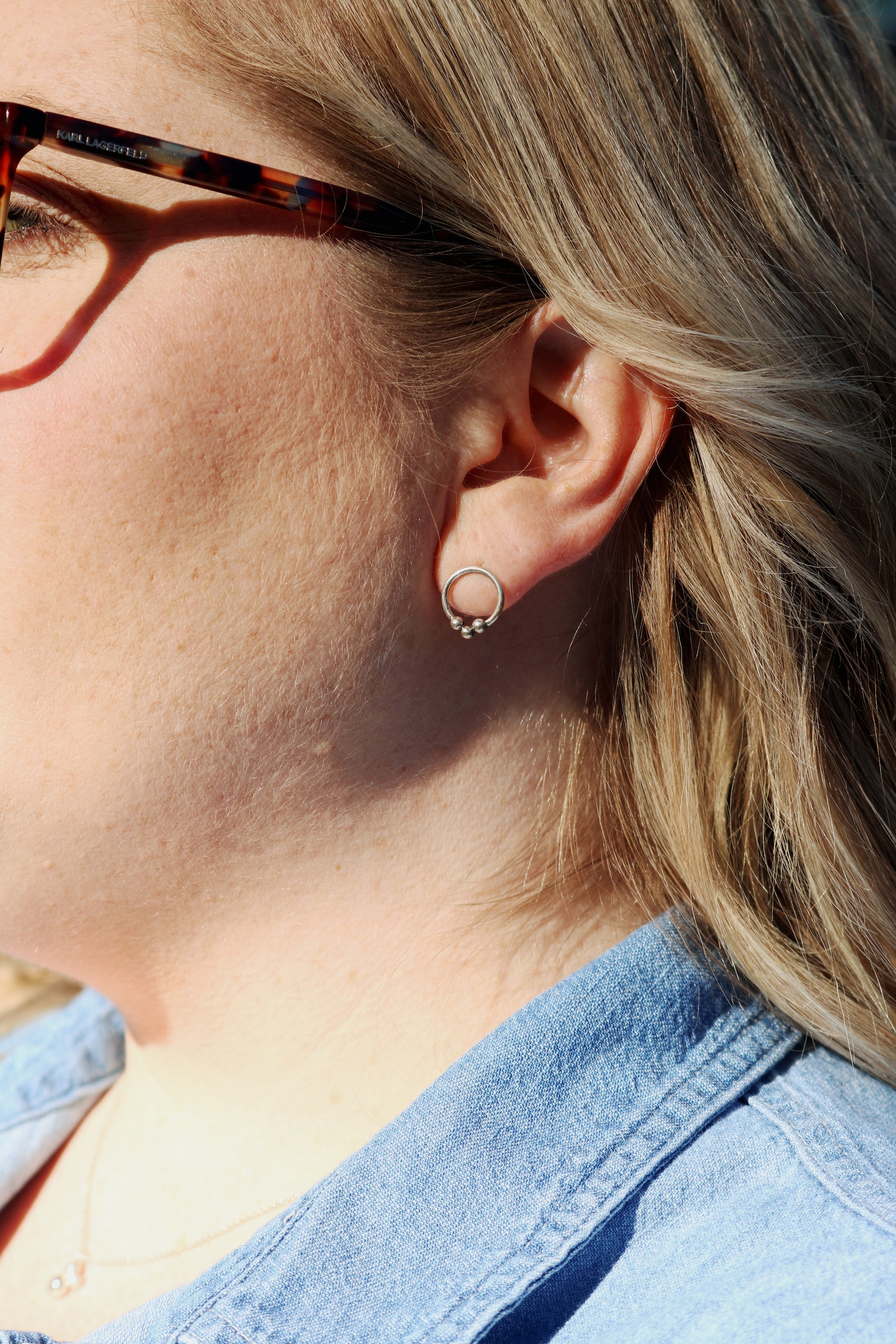 Sterling silver circle stud earrings with three silver bubbles at the bottom.