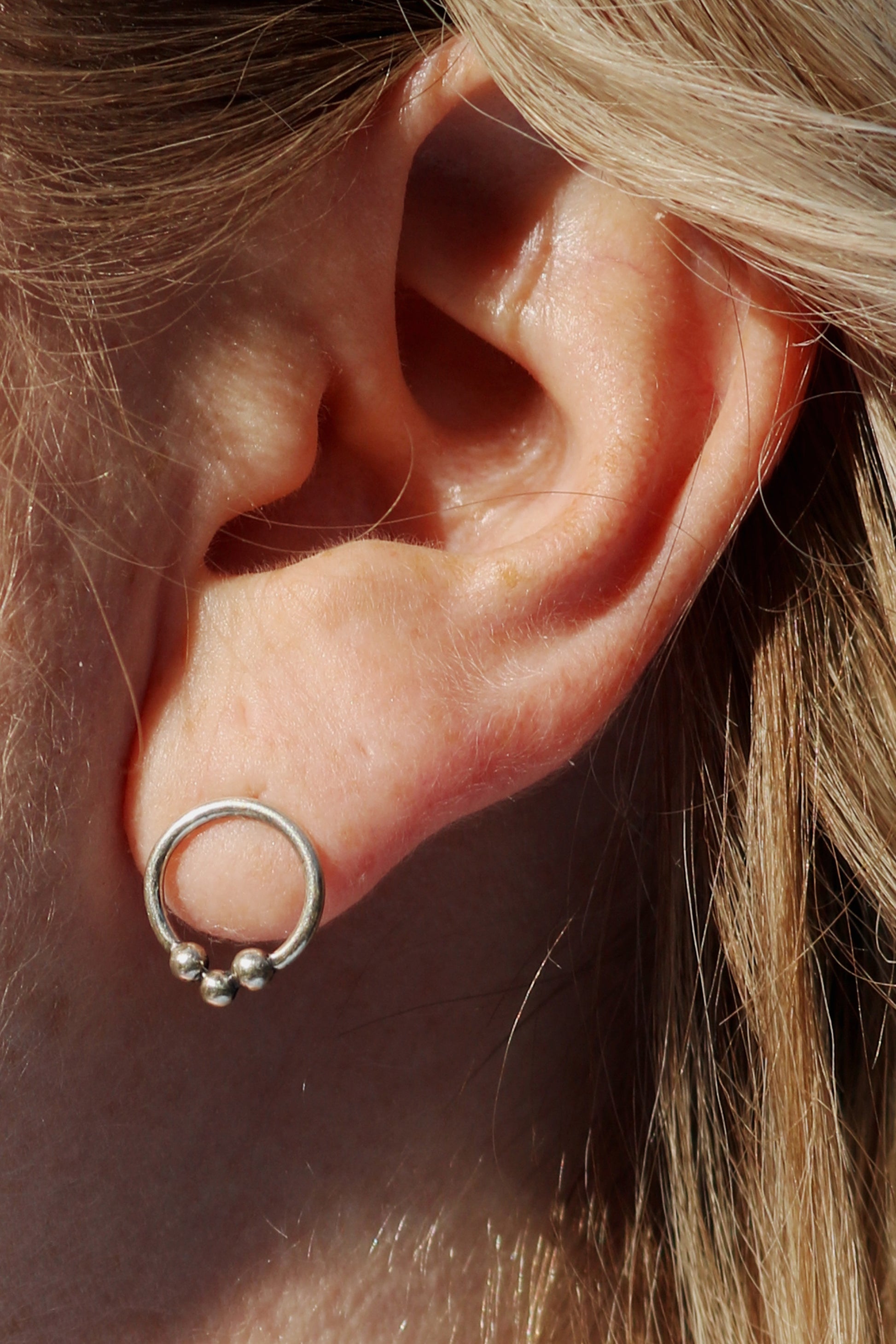 Sterling silver circle stud earrings with three silver bubbles at the bottom.