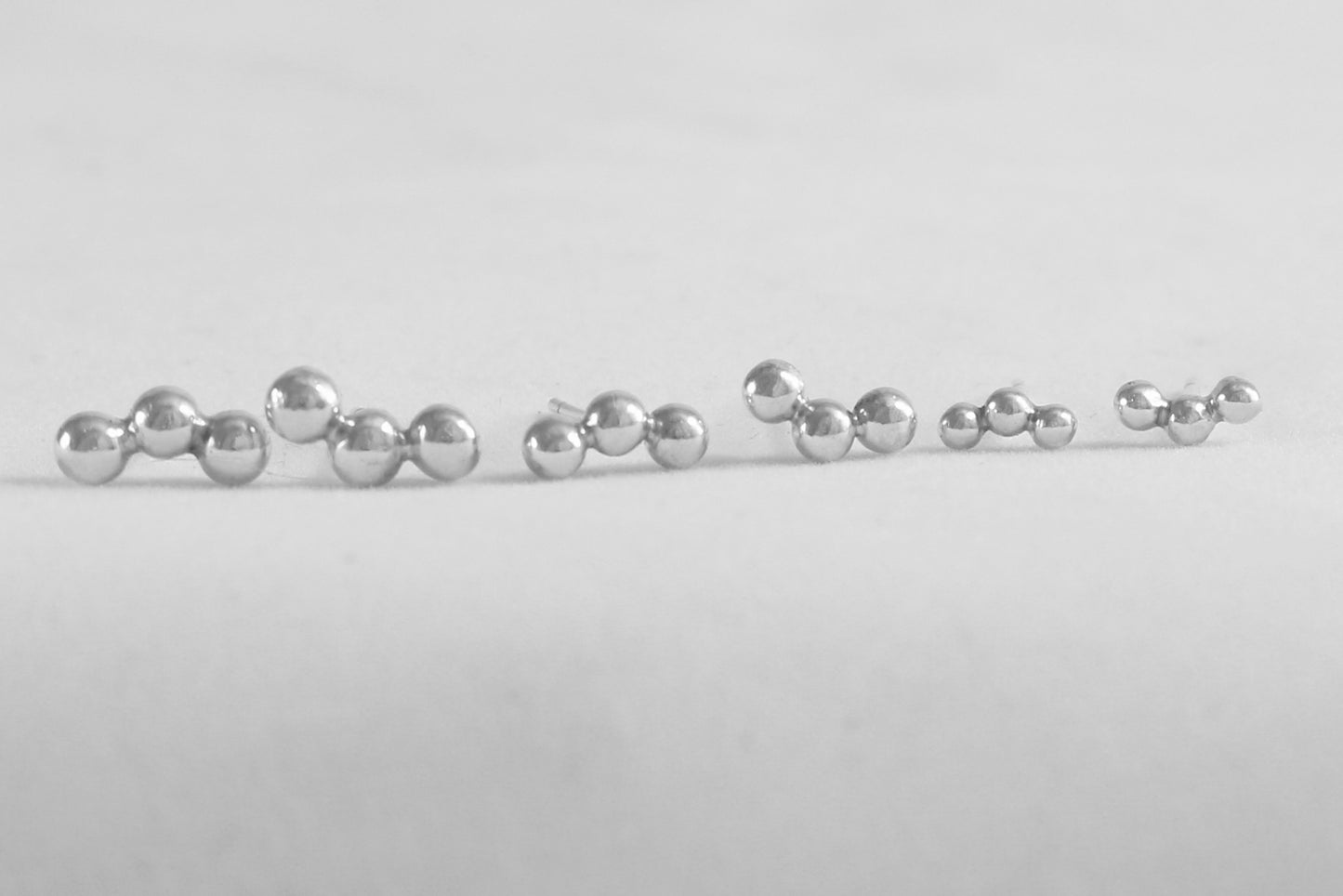 Sterling silver studs with three bubbles along a curve.