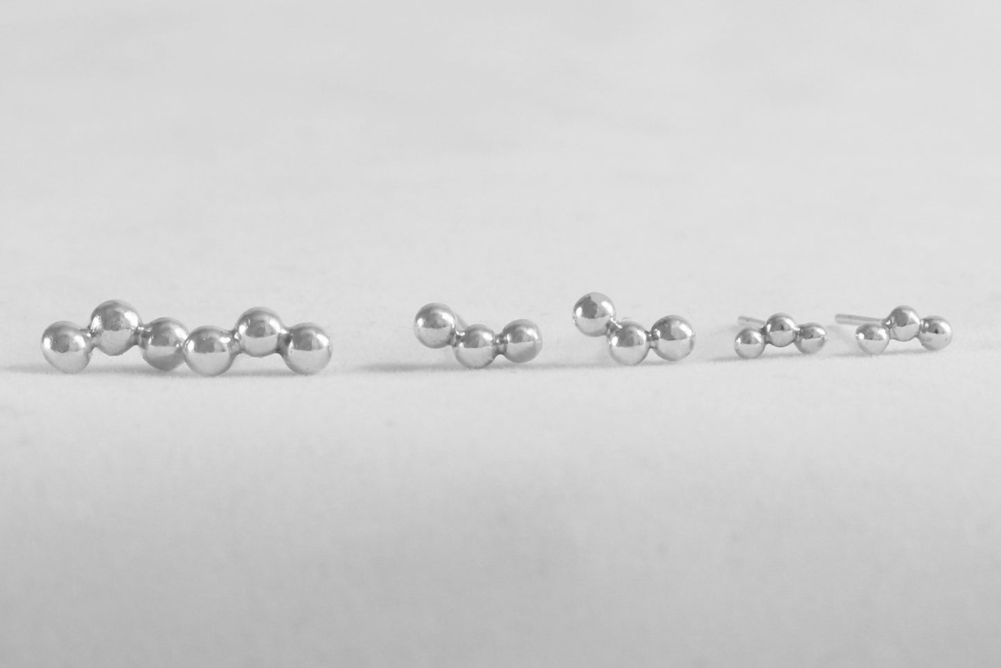 Sterling silver studs with three bubbles along a curve.